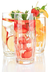 Glasses of fruit drinks with ice cubes isolated on white