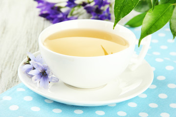 Cup of tea with chicory, on wooden background