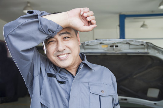 Auto Mechanic Wiping The Sweat Off His Brow