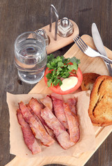 Bacon on plates on board on wooden table