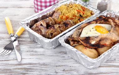 Food in boxes of foil on wooden table