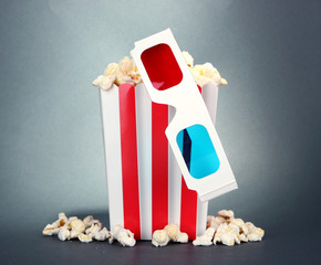 Popcorn and 3D glasses on grey background
