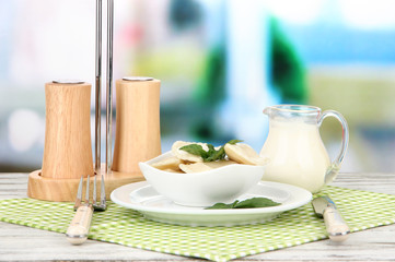 Tasty dumplings on white plate, on bright background