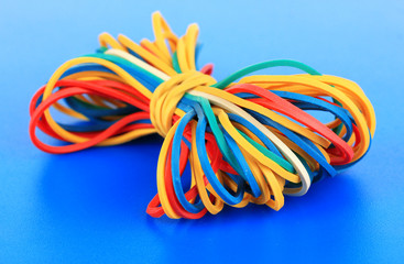 Colorful rubber bands on blue background
