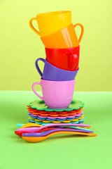 Set of children's dishes on light green background