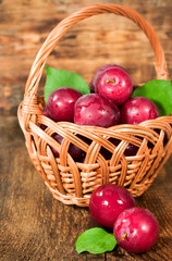 ripe plums in a wicker basket