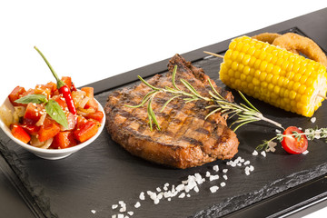 Grilled steak with sauce and greens