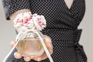 Young woman holding bouquet of carnation flowers