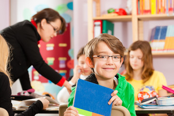 Schulkinder und Lehrerin lernen an der Schule