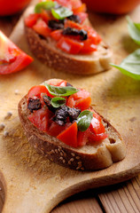 bruschetta italiana con pomodoro, olive nere e basilico