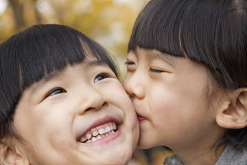 Obraz premium A girl kissing her older sister