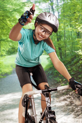 portrait of female bike rider outside and showing thumbsup. comp