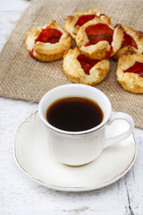 Cup of coffee and small cakes on wooden rustic table