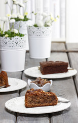 Chocolate cake on grey wooden table. Bookshelves in the backgrou