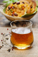 Glass of hot steaming tea, basket of buns in the background