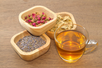 Flowers tea collection in a wooden bowl with cup of tea