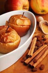 Baked apples in white bowl and ingredients.