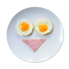 breakfast smiley face with bacon and fried eggs on white plate