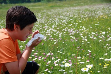 allergic child to pollen and flowers with a handkerchief while s