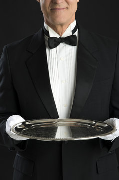 Midsection Of Waiter Holding Serving Tray