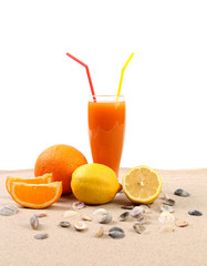 Juice, orange, lime, shells on sand.