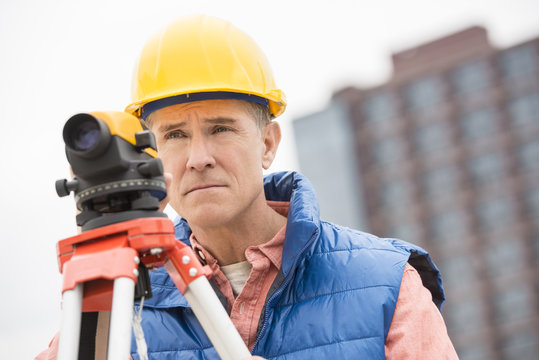 Confident Construction Worker With Theodolite Looking Away