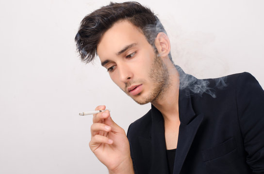 Young beautiful businessman smoking
