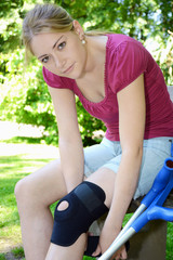 Frau legt Kniebandage an