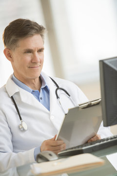 Doctor Smiling While Looking At Computer