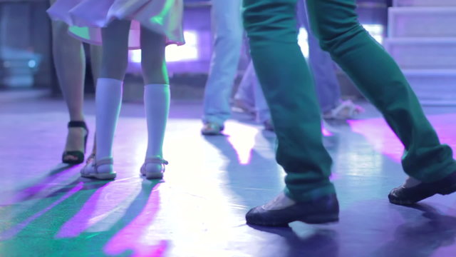 Feet of dancing people, male, female, and child. Grooving music