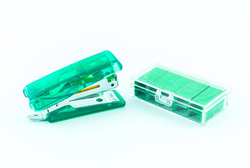 Green stapler and bunch of staples isolated on white