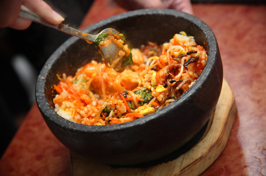 Korean cuisine : bibimbap in a heated stone bowl mashing