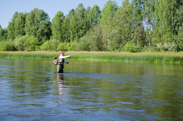 Fototapeta na wymiar Fisherman catches of chub fly fishing in the Chusovaya river