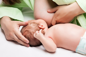 Obraz na płótnie Canvas Little newborn baby child sucking or eating mother breast milk