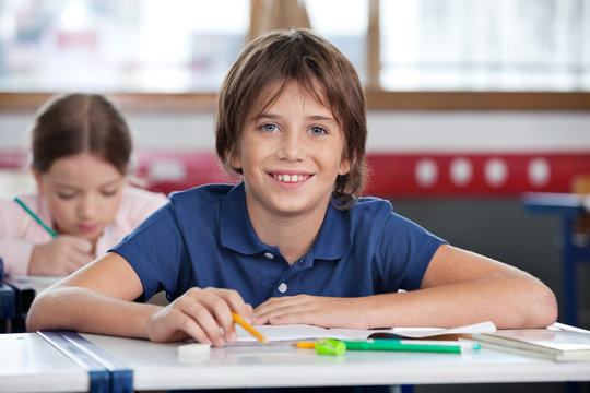 Cute Schoolboy Smiling In Classroom