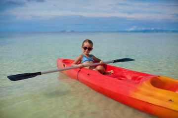 brave little cute girl floating in a kayak on the high seas
