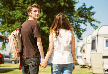Fototapeta premium Teenage couple walk touching hand in hand