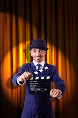 Man with movie clapper on curtain background