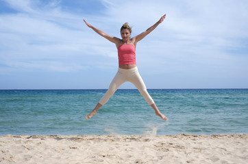 Fototapeta na wymiar Girl jumping on the beach in Sardinia