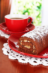 Sweet roll with cup of tea on table in room