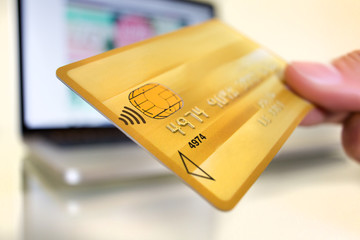 Hand holding plastic card on open notebook background