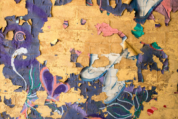 cracked graffiti on a brick wall