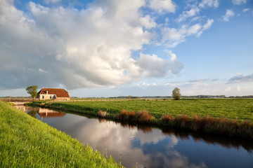 Fototapeta premium charming farmhouse, river and blue sky