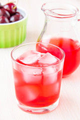 Delicious sweet berry lemonade of cherry in glass and carafe