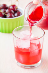 Fototapeta na wymiar Delicious sweet berry lemonade of cherry pour out into the glass