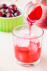 Delicious sweet berry lemonade of cherry pour out into the glass
