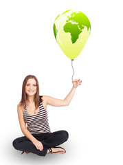 Happy lady holding a green globe balloon