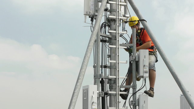 caucasian contractor working on a telecommunications mast at hei