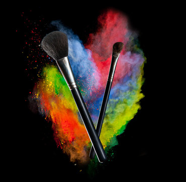 Colored powder with brushes, isolated on black background