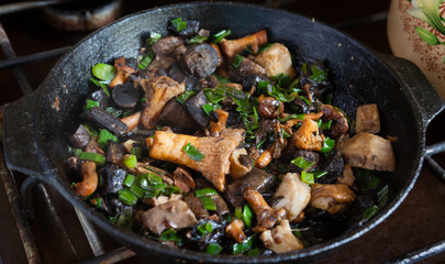 assorted mushrooms is fried in a pan